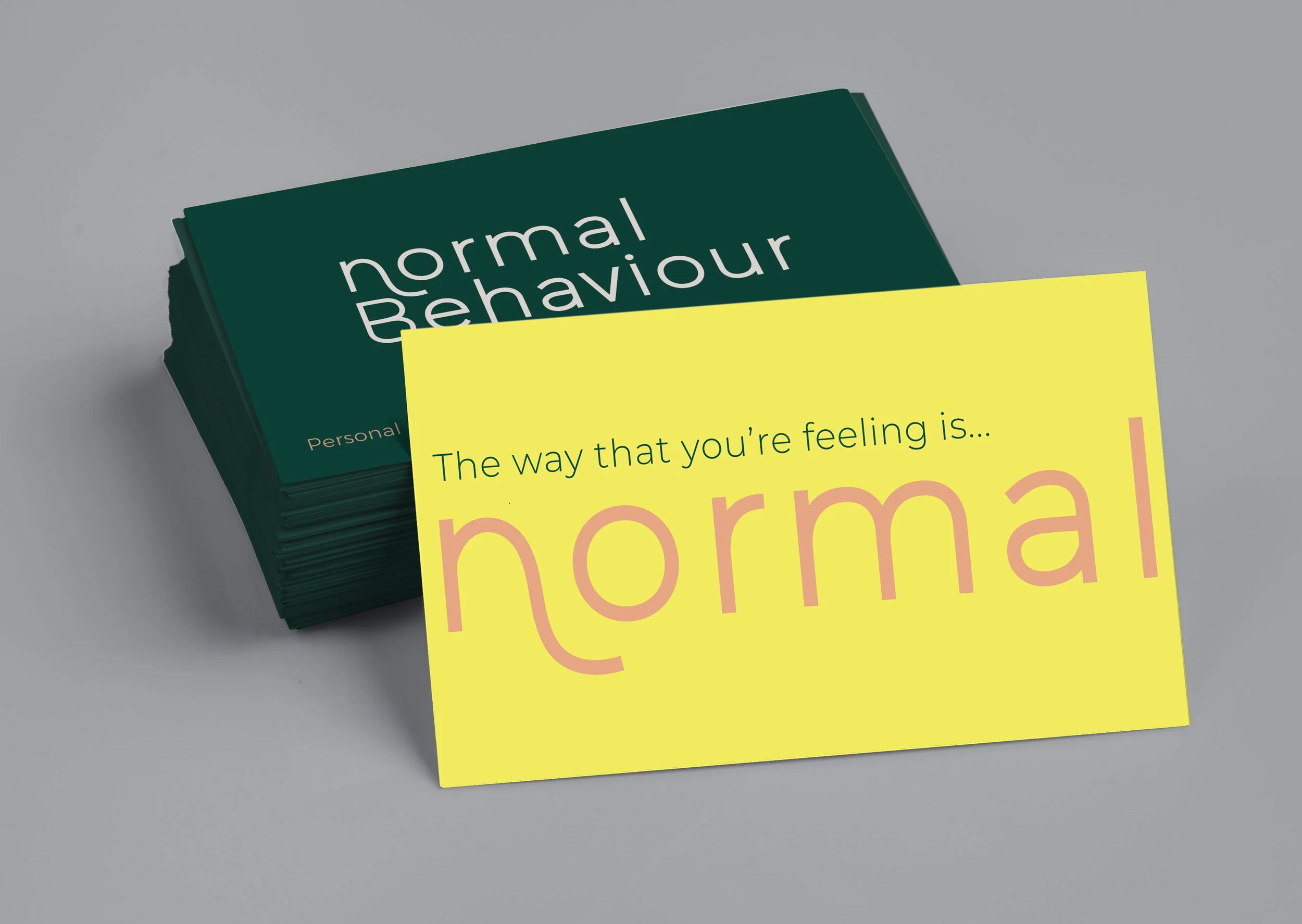 business cards that read "The way that you're feeling is...normal", yellow on front, dark green on back