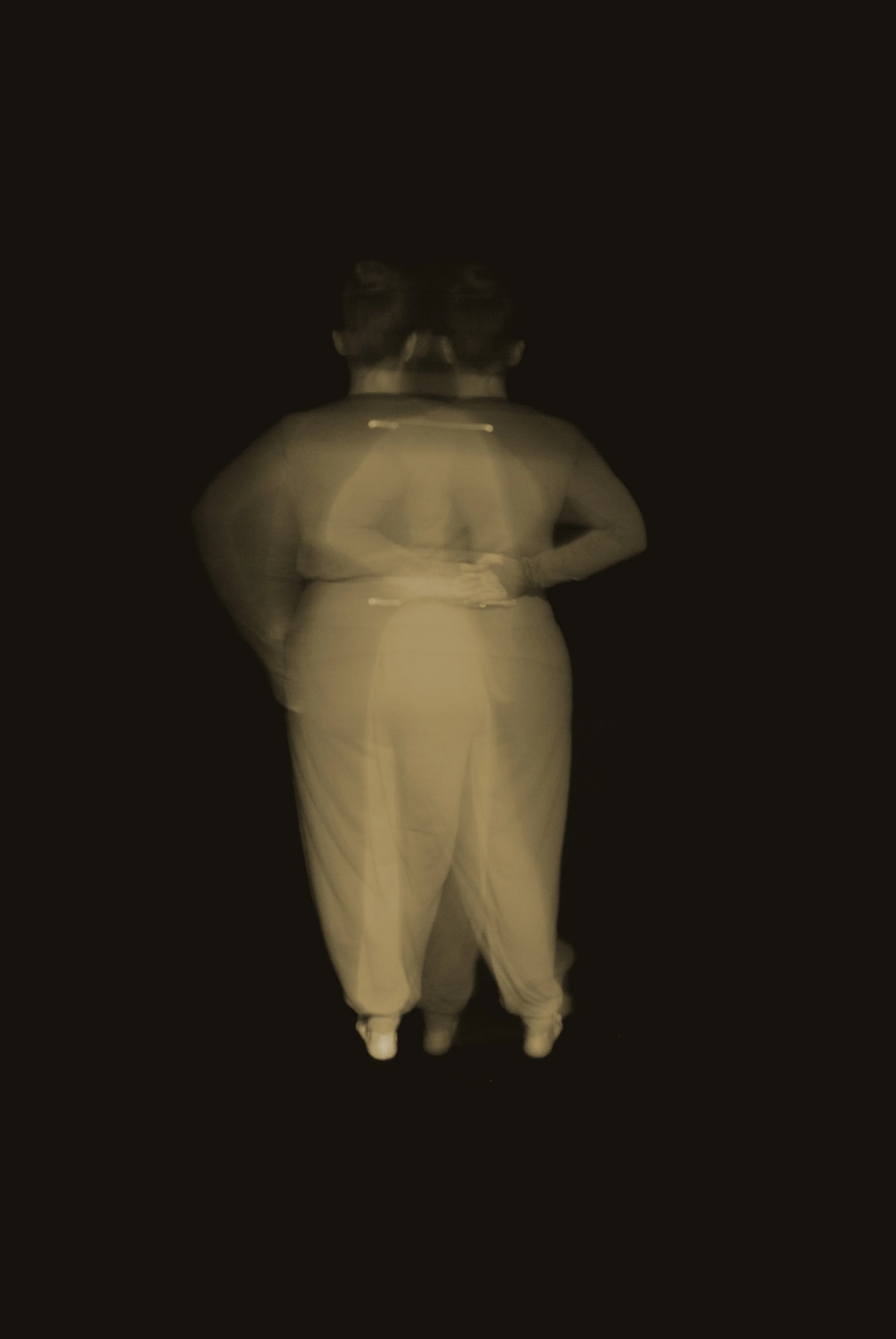 long exposure of body moving into 'at ease' posture' in neutral palette with black background
