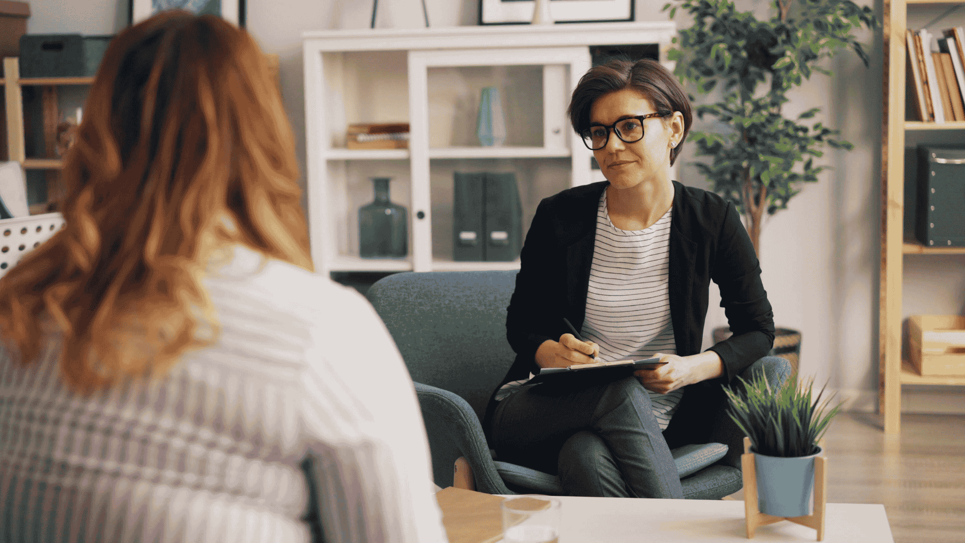 Therapist listening attentively to a woman during a counseling session.