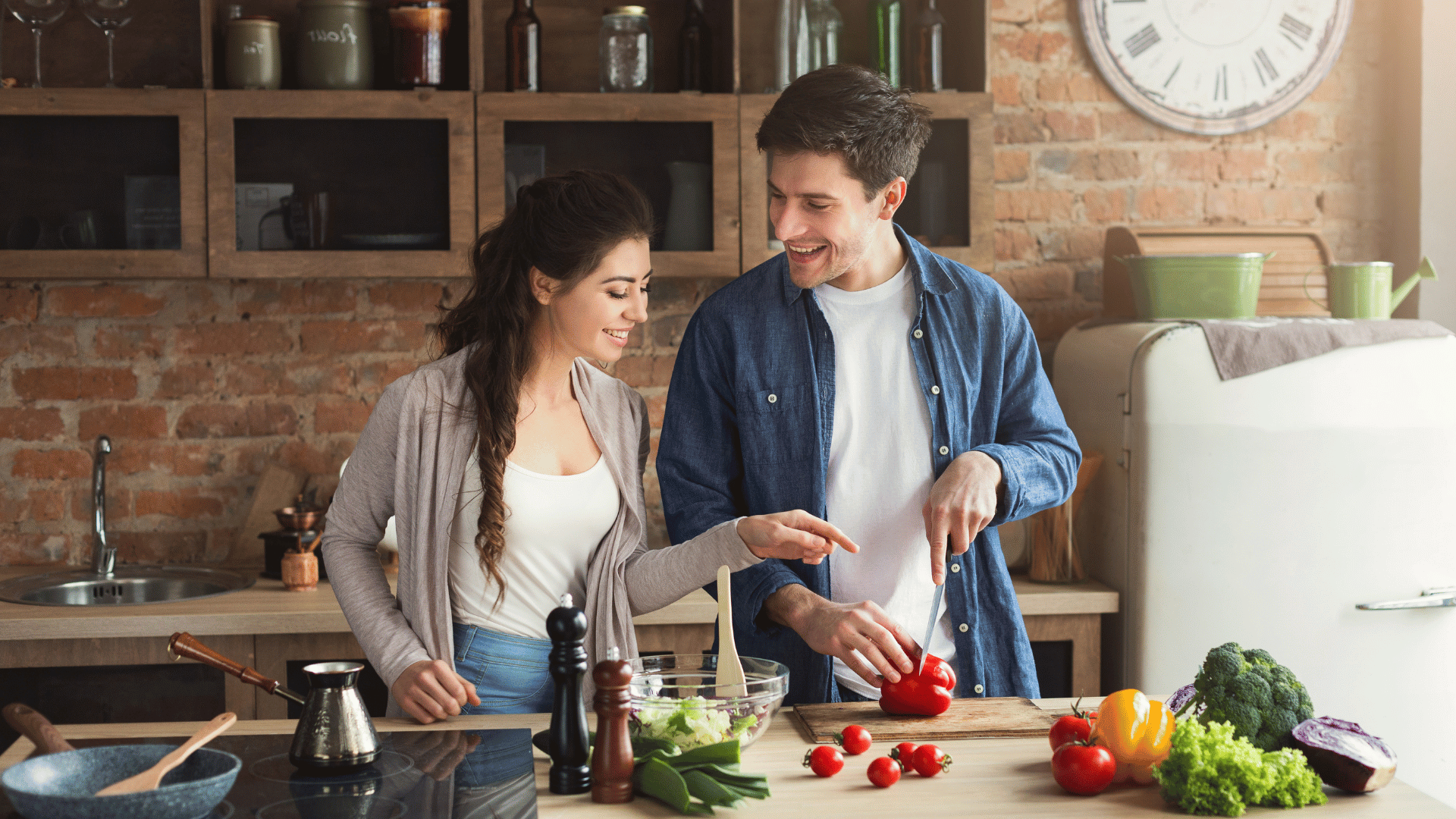 Young happy married couple cooking together in kitchen, husband helping with meal prep – supportive relationship and shared household duties