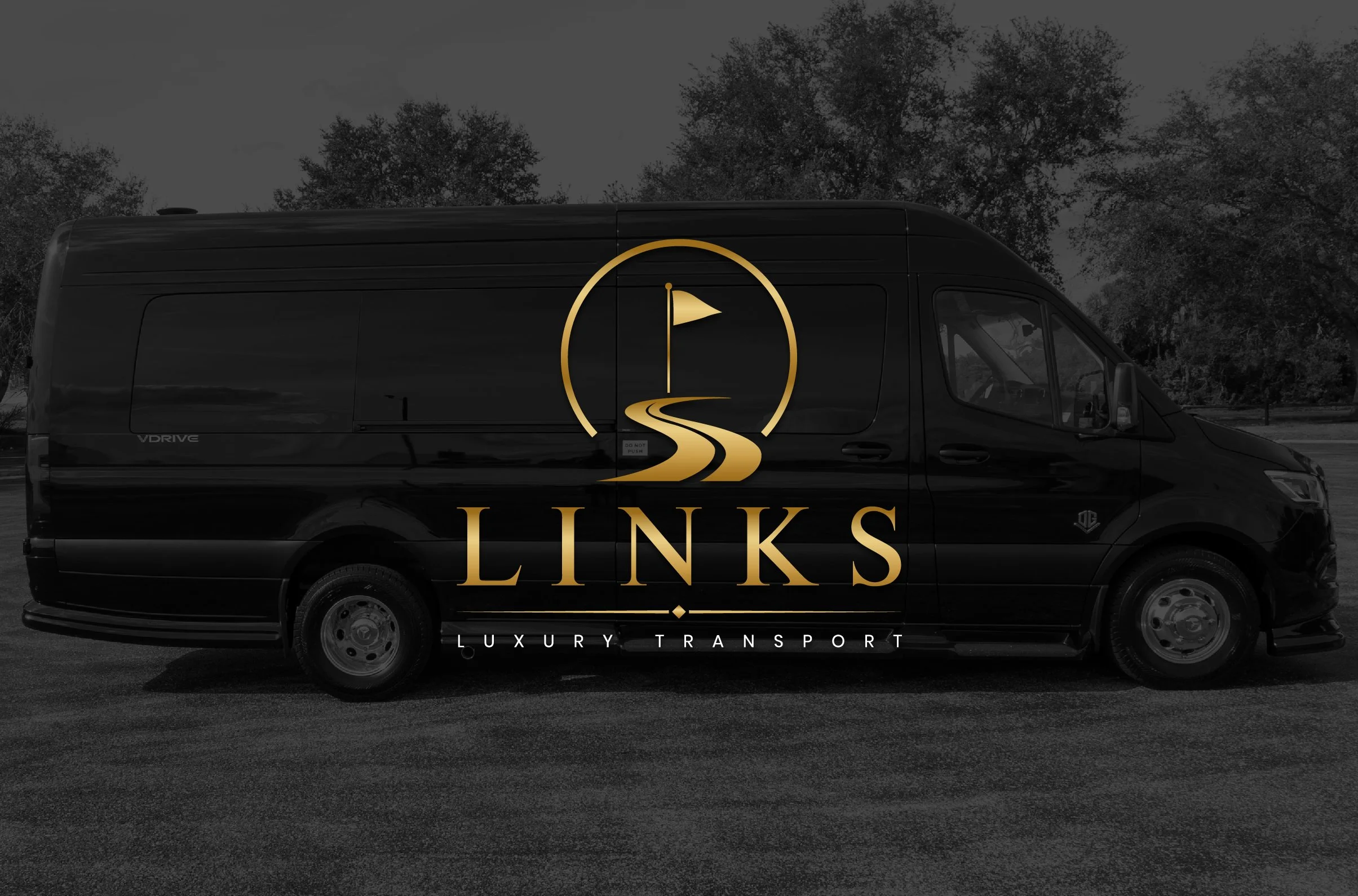 A black luxury van with a logo of a winding road leading to a flag inside a gold circle. The words 'Links Luxury Transport' are written below the logo.