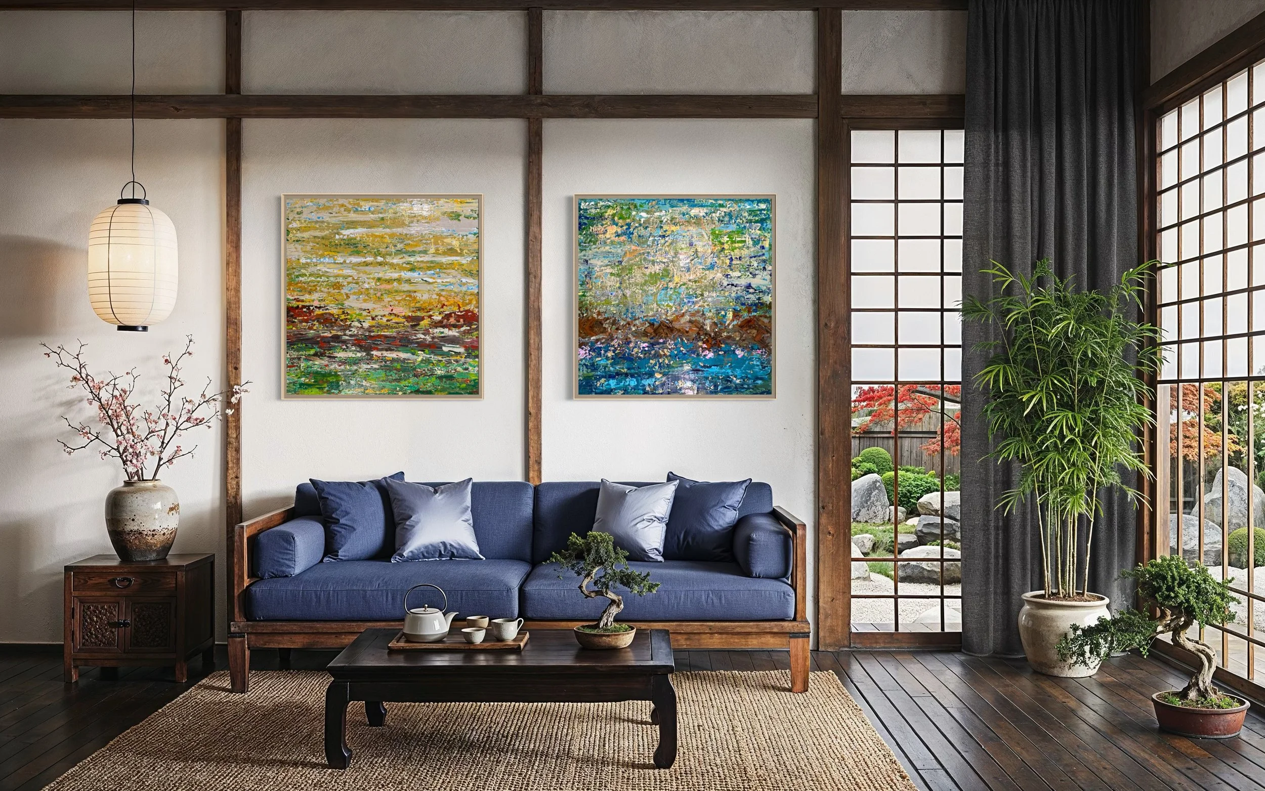 The Pond Dreams in Blue shown as a twin pairing beside The Marsh Dreams in Gold by Roya Rad, framed above a navy sofa in a serene Japanese-style room. Digital mockup for scale reference.