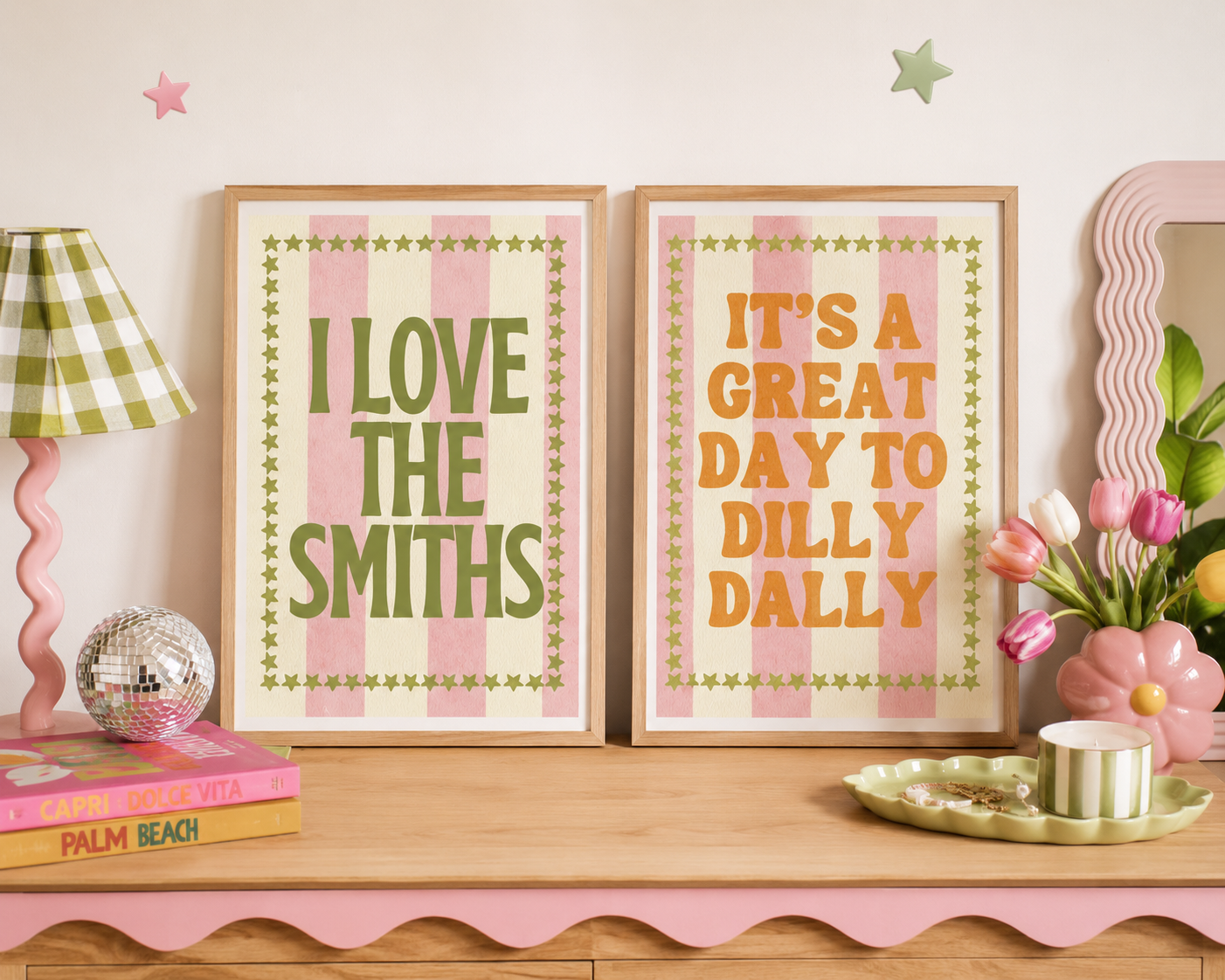 Two prints in frames next to each other. Both are pink stripes with green stars around the border. The left piece says "I love the smiths" and the right piece says "It's a great day to dilly dally".