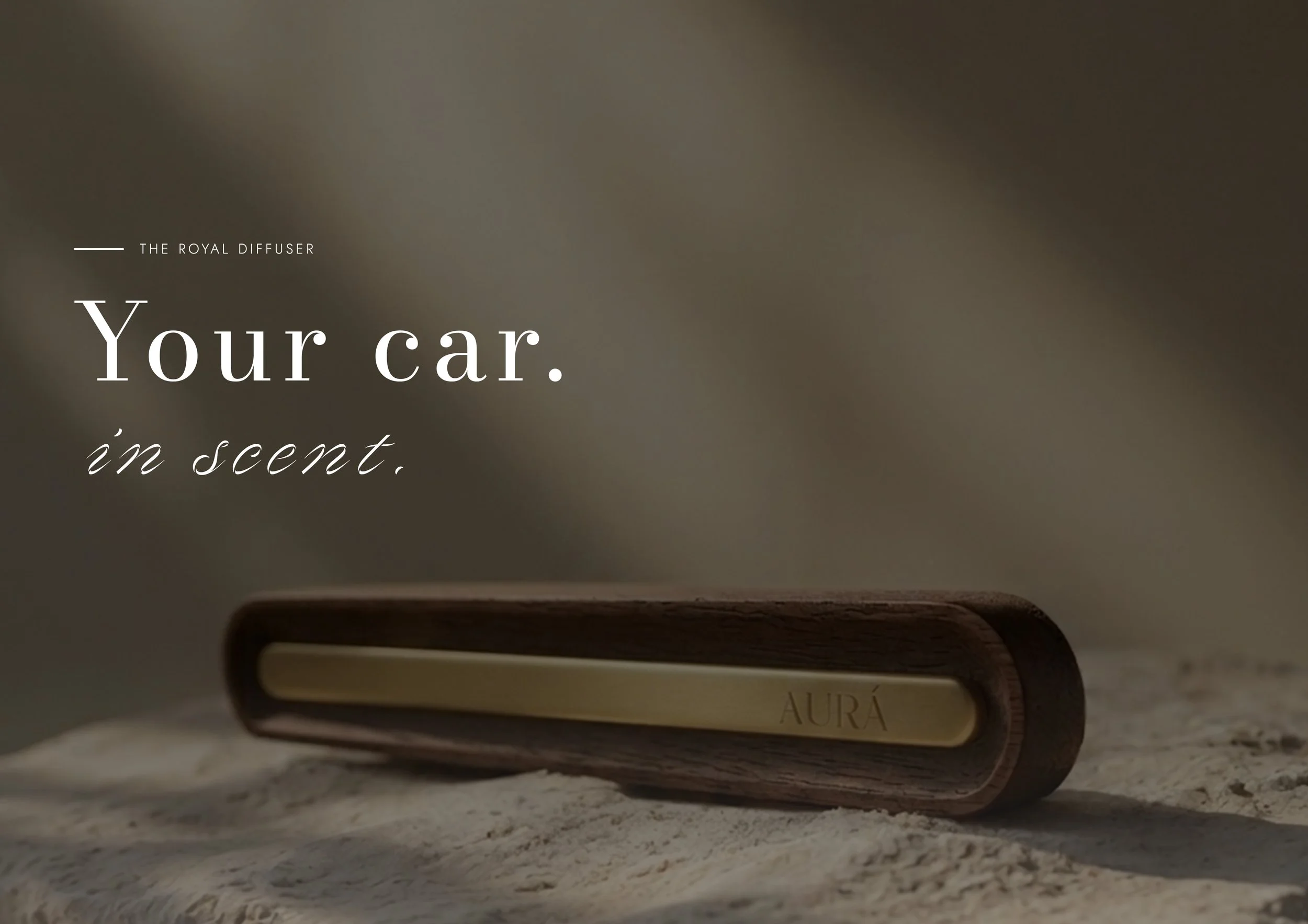 A perfume bottle labeled 'AURA' on a textured surface with text overlay reading 'The Royal Diffuser Your Car. in scent.'