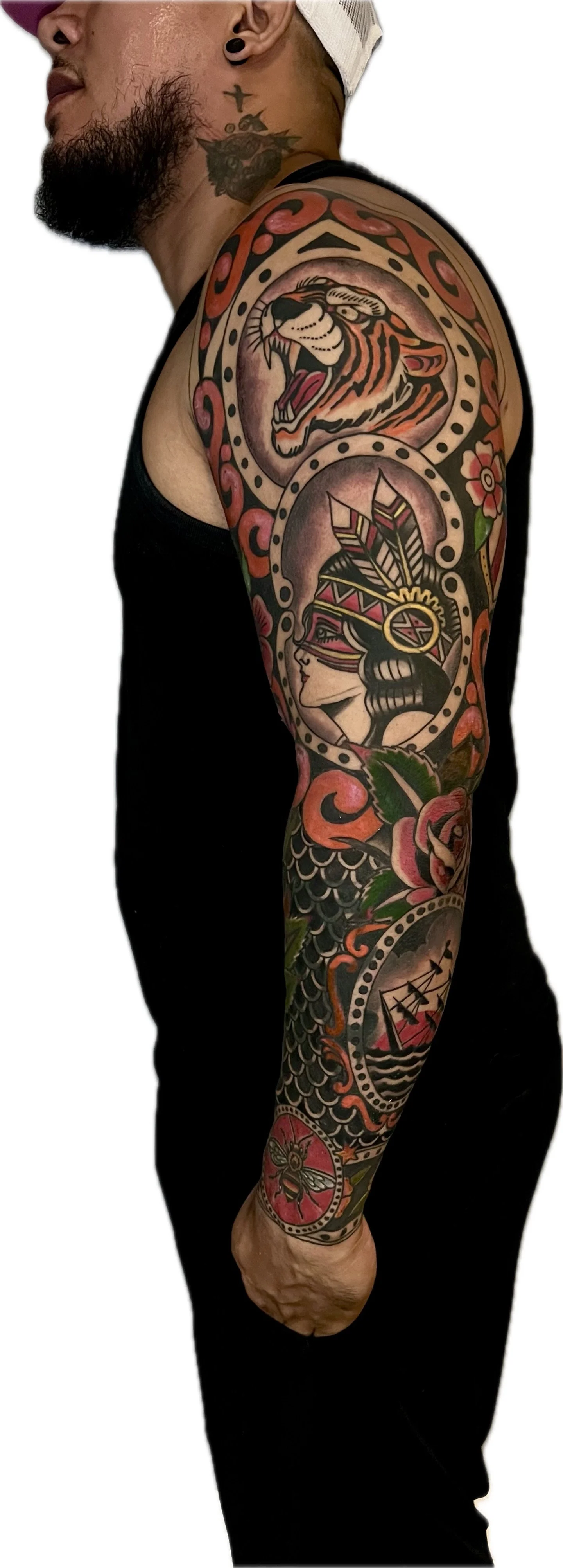 Tattoo sleeve featuring a roaring tiger, a Native American woman with feathers in her hair, a sailing ship, flowers, a spider, and decorative patterns.