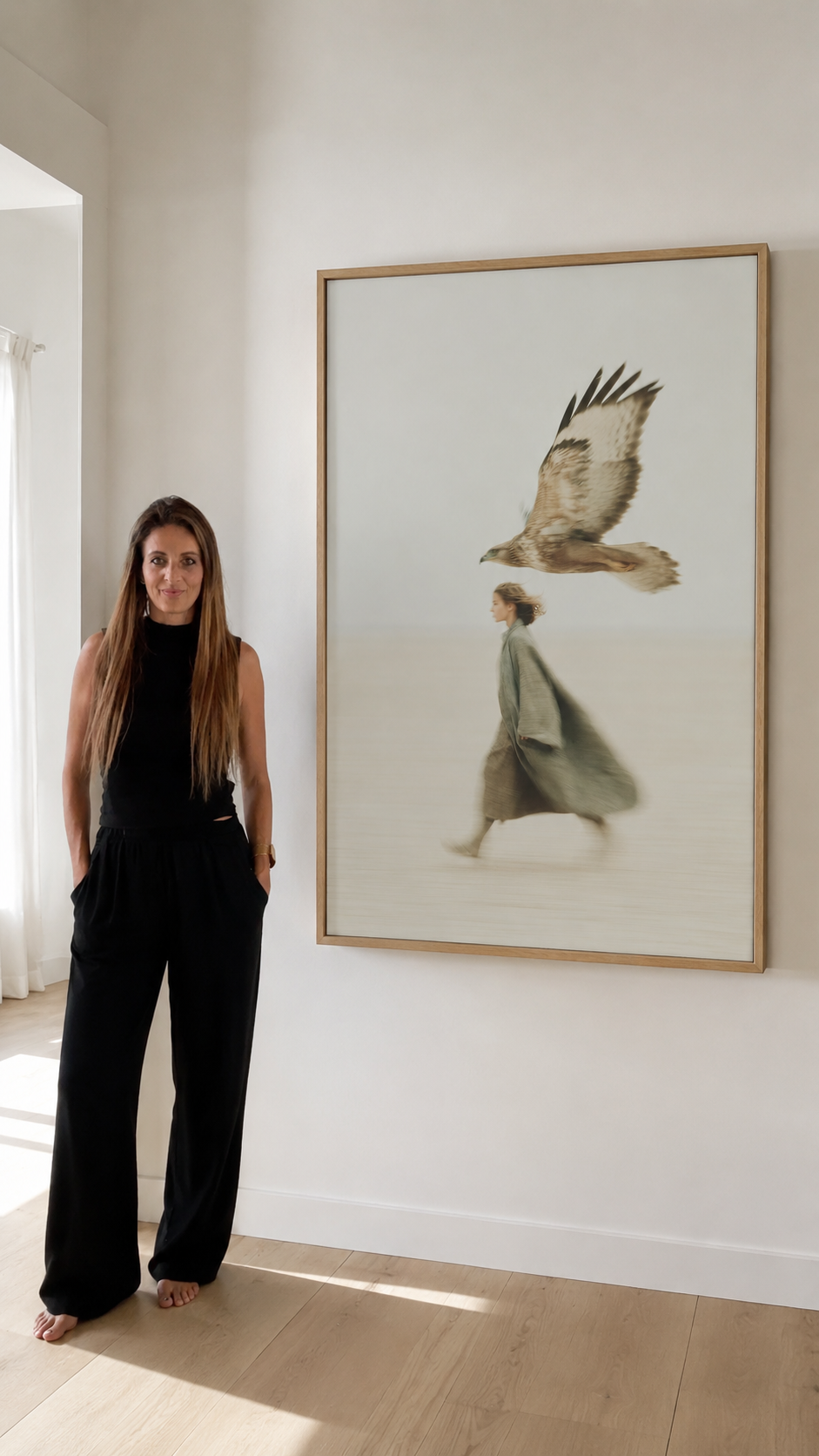 Woman standing next to wall art depicting a woman and a bird in motion.