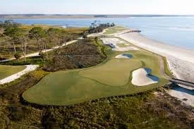 A coastal SSI golf course with green fairways, sand bunkers, and ocean views.