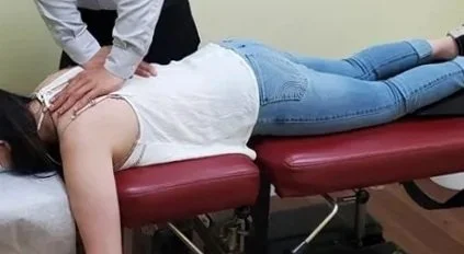 A person receiving chiropractic treatment on a massage table.