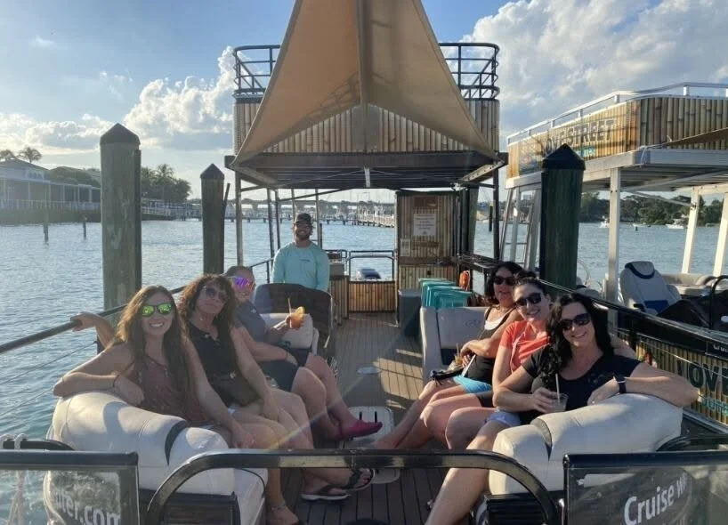 Group of women sitting and relaxing on a boat docked at a marina.