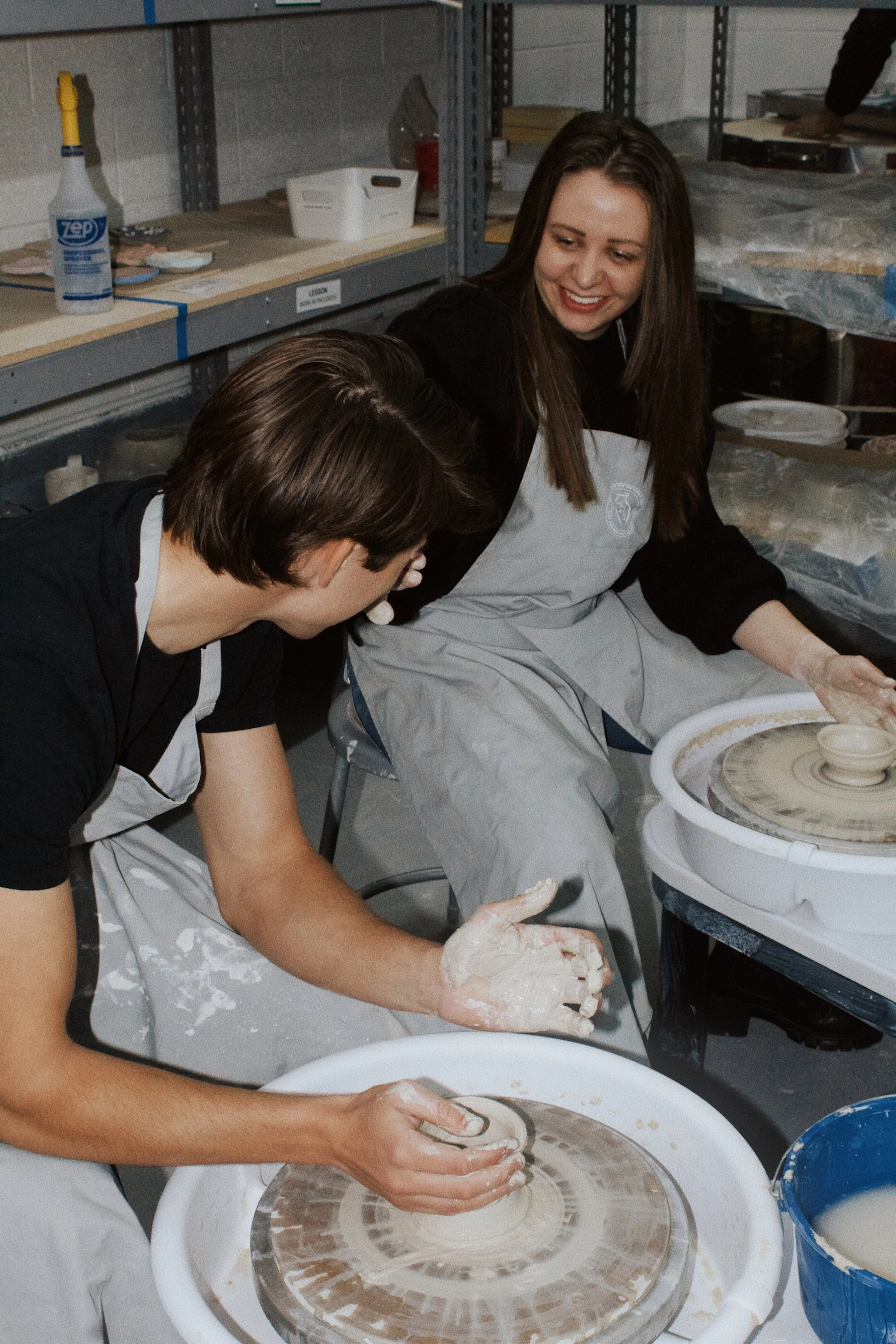 Helpful pottery instructor encouraging a pottery student.