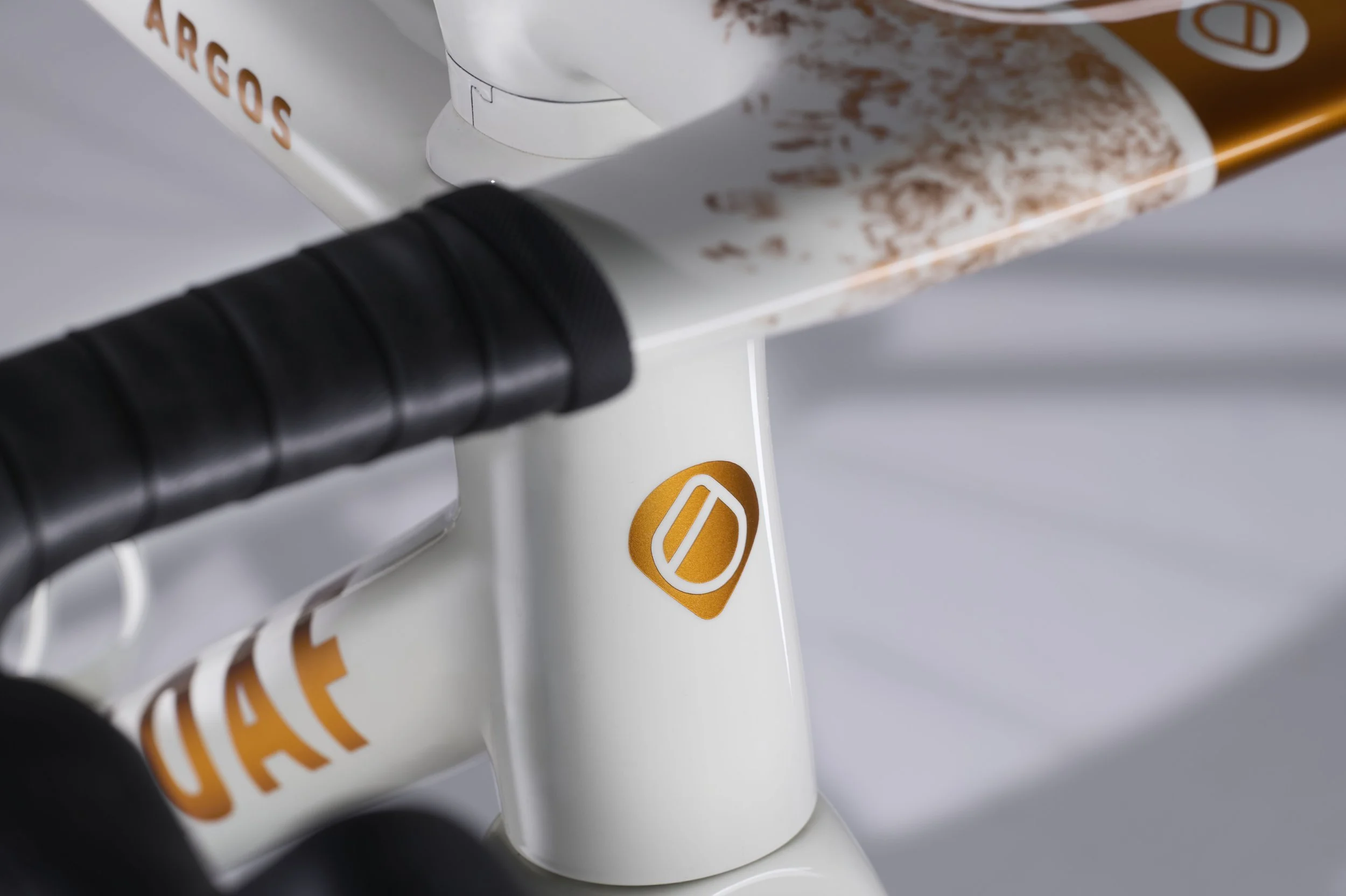 detail of headstock tube of sugarloaf Argos with copper logo with shadows across the background