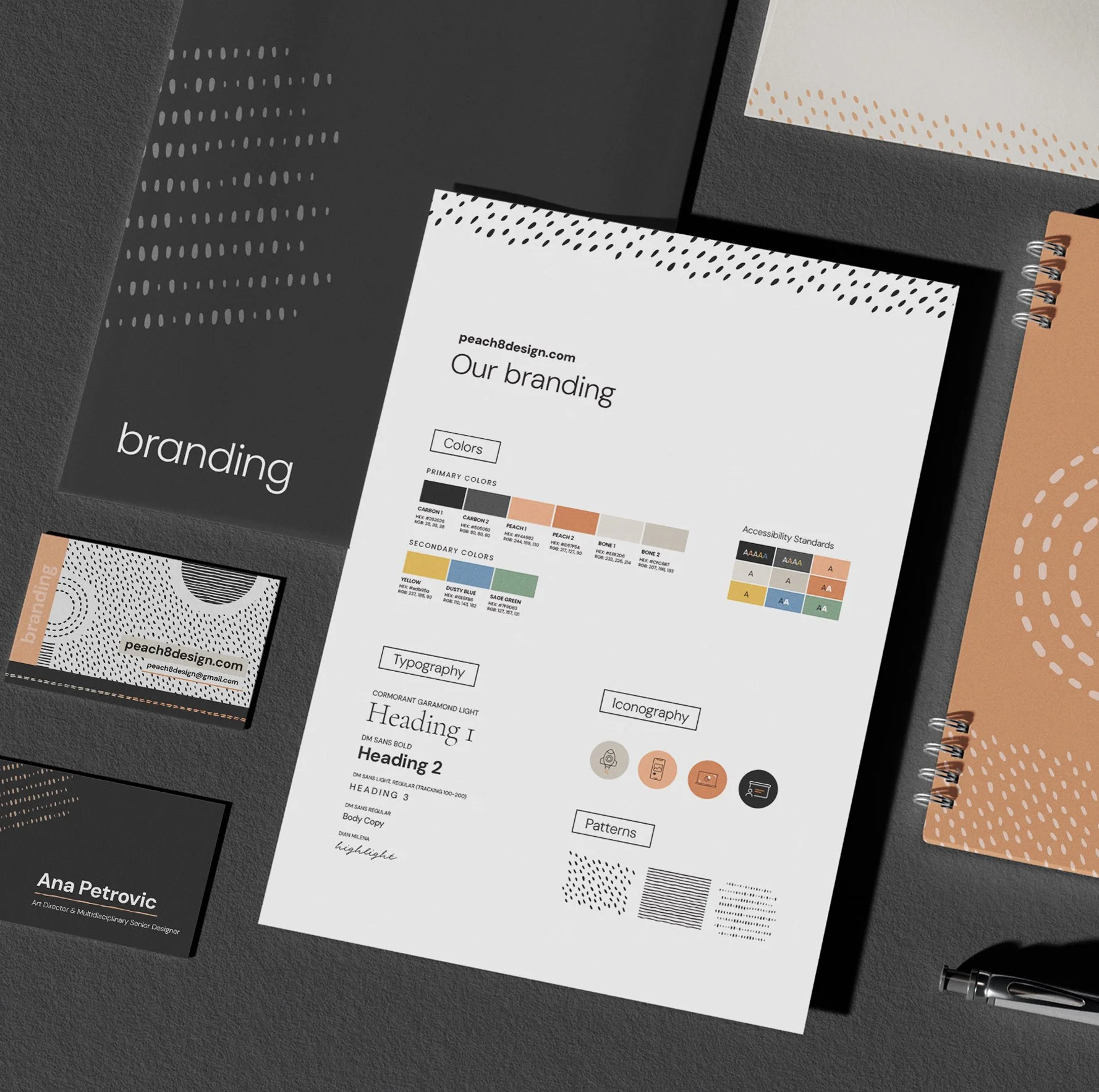 A collection of design and branding materials, including a presentation or report on branding colors, typography, patterns, and accessibility standards, along with business cards and notebooks on a textured surface.