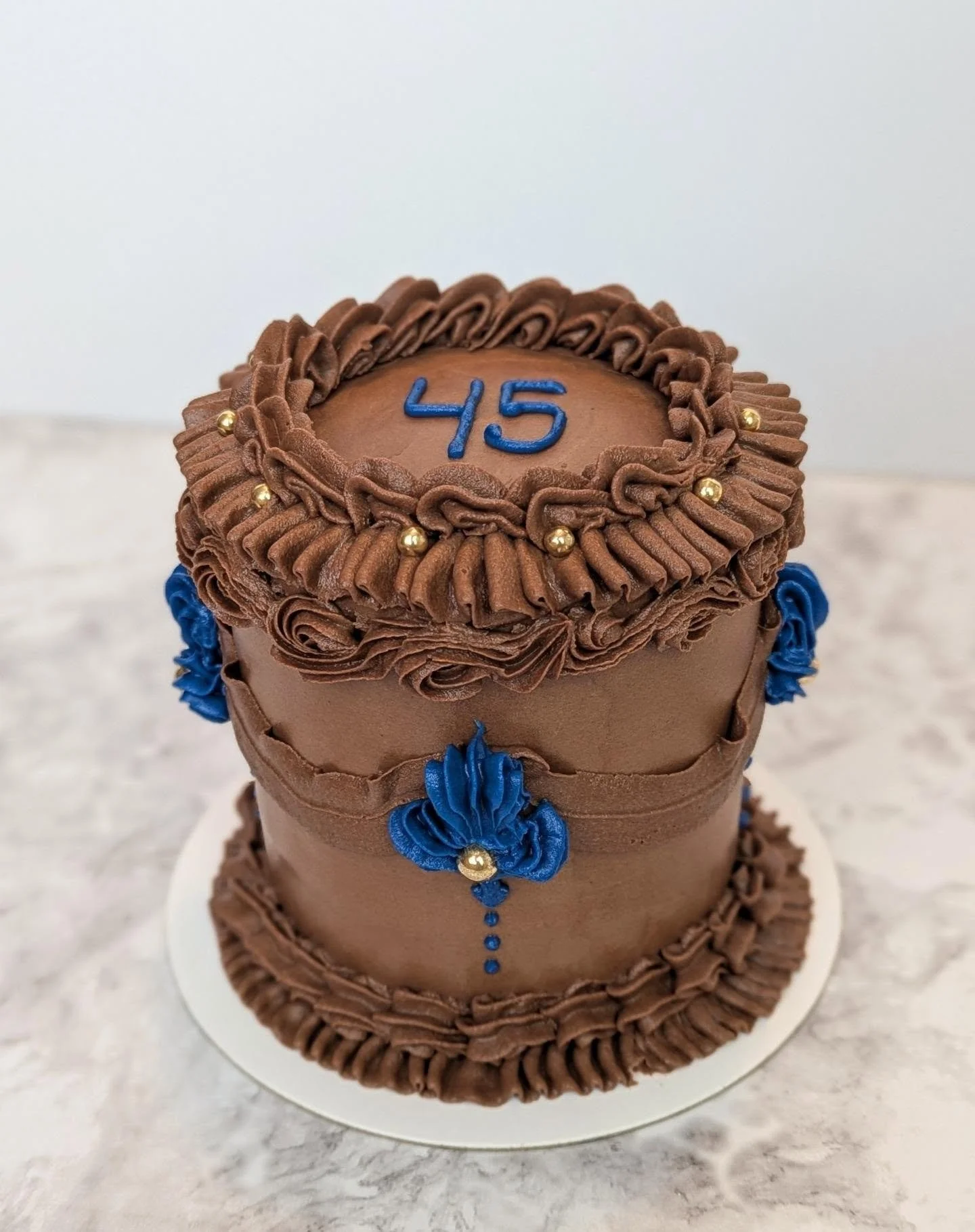 Today is my in-law's 45th wedding anniversary, so I surprised them with a sweet little cake to celebrate the big milestone 🥳

This one is a 4" chocolate cake with coffee buttercream filling, covered in chocolate buttercream with edible gold pea