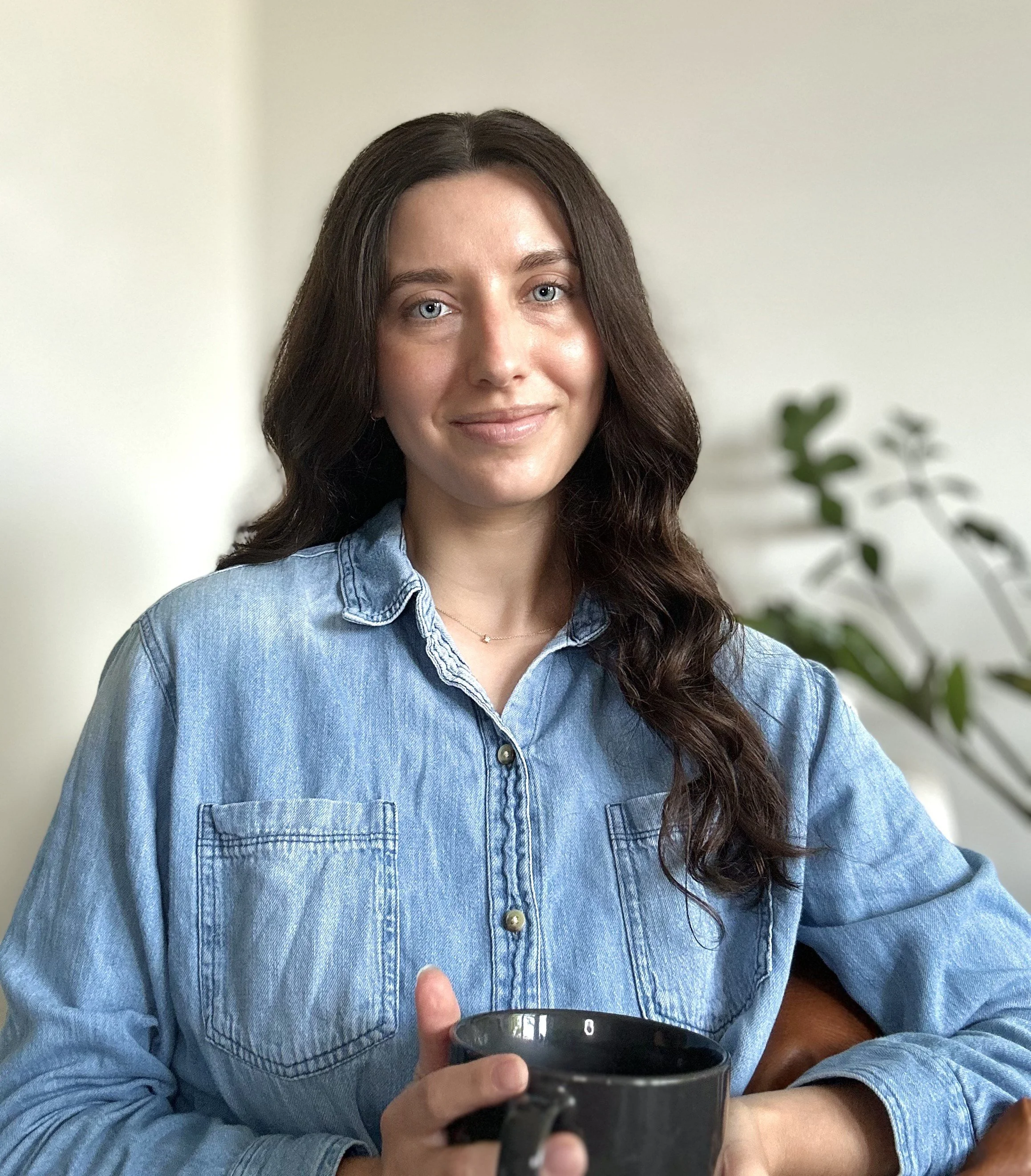 Headshot photo of Avero Coffee founder, Erika holding a coffee mug.