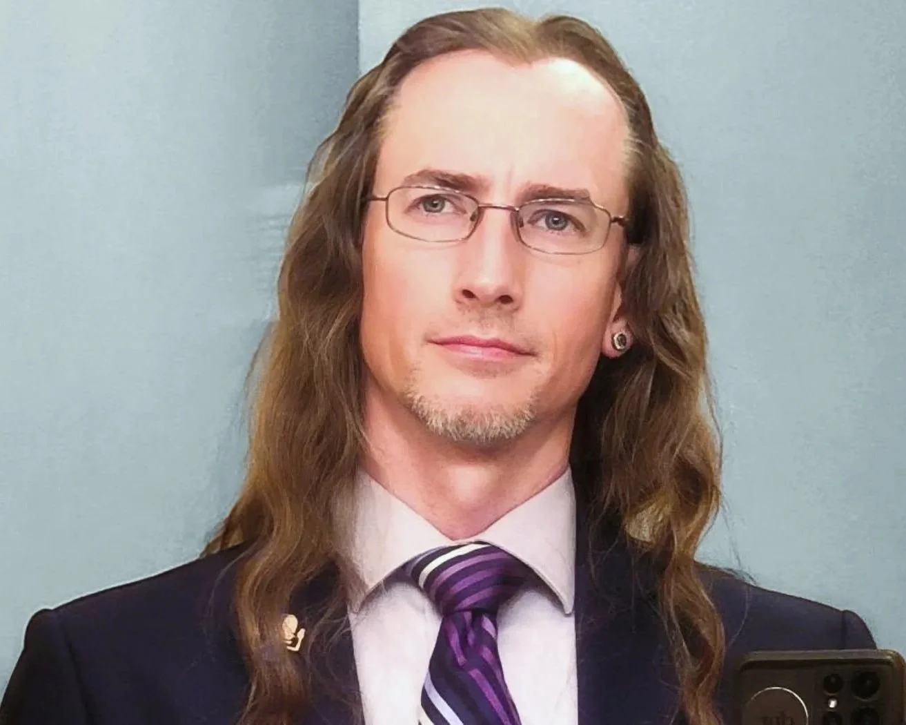 A man with long wavy hair, wearing glasses, a white shirt, dark suit, and a purple striped tie, posing for a photo. Brice Williams ; Brice A. Williams ; Coach Brice Williams.  Academic , professor, classy, teacher. 