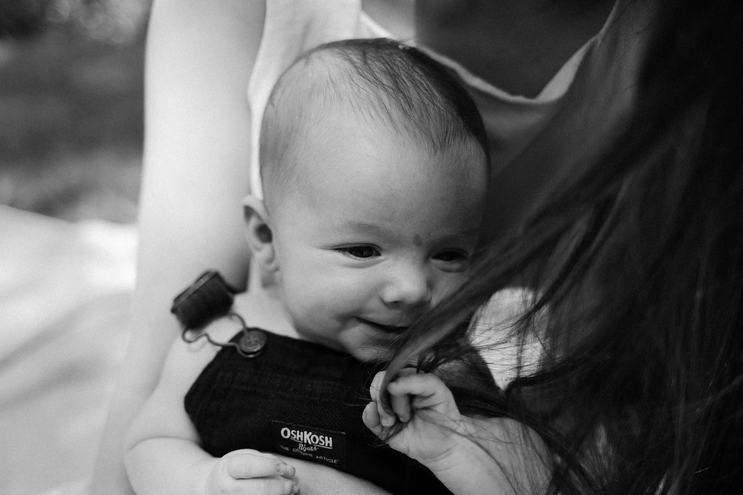 A young child getting a hug from an adult, possibly a parent, with a focus on the child's face and expression of comfort.
