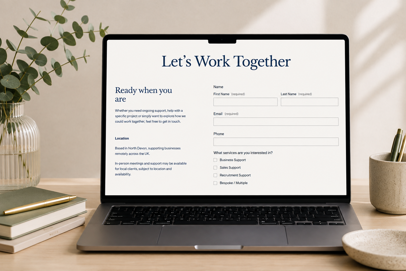 Laptop on a wooden desk displaying a support contact form titled "Let's Work Together" with fields for name, email, phone, and service interests; Business support, admin support, sales support, recruitment support in North Devon and UK