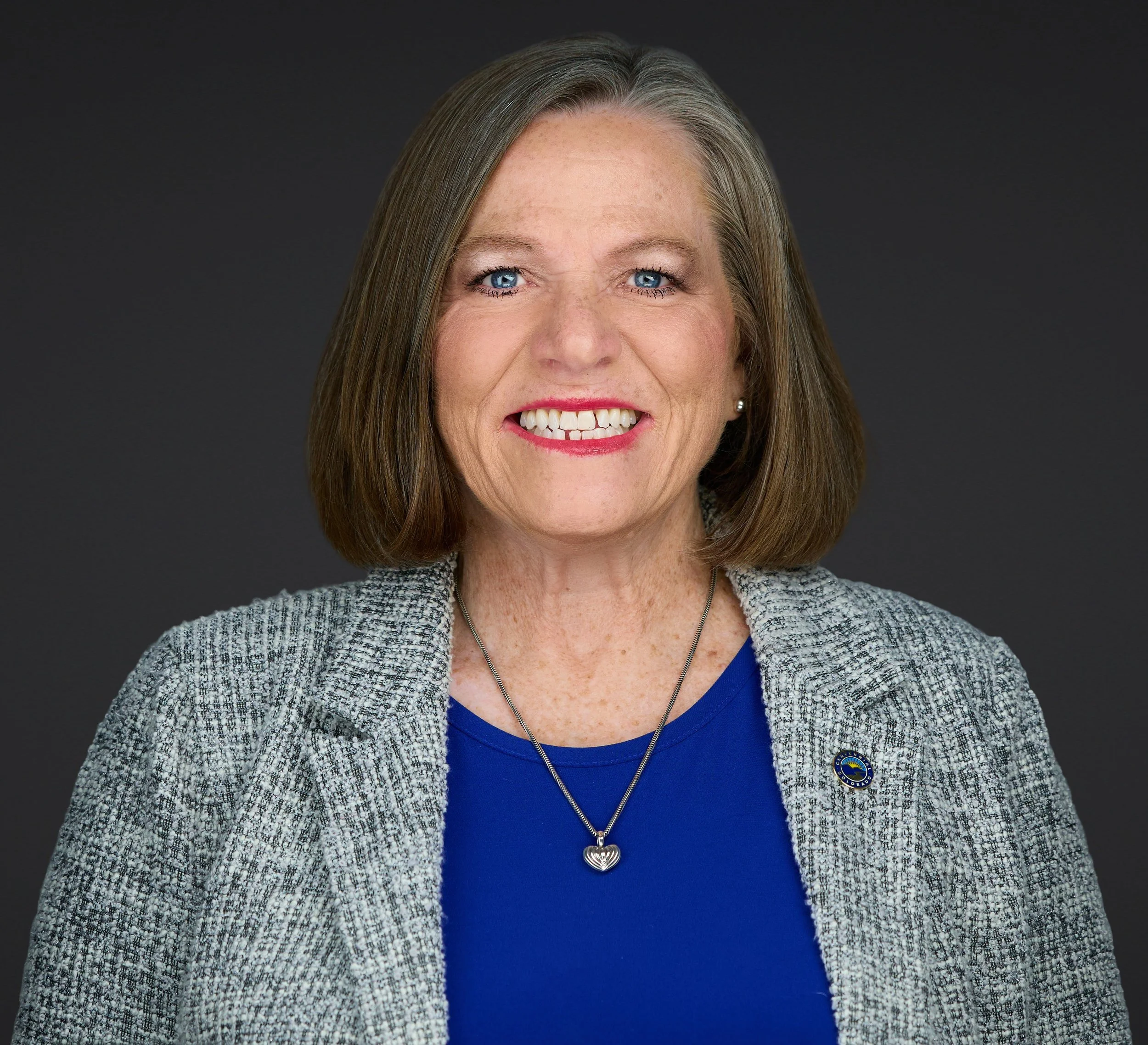 Smiling woman with shoulder length hair and a blue shirt