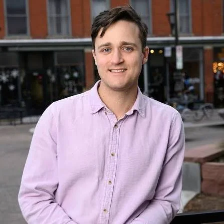 Smiling man in a lavender shirt
