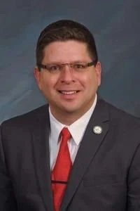 Smiling man with glasses and a red tie