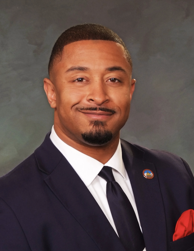 Smiling man with a black suite and red pocket square