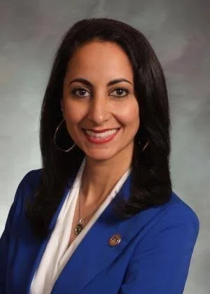smiling woman with dark hair and a blue jacket