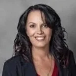 Smiling woman with dark, wavy hair wearing a dark jacket