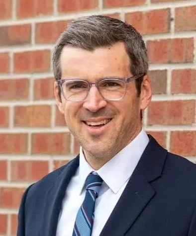 Smiling man with glasses wearing a blue tie