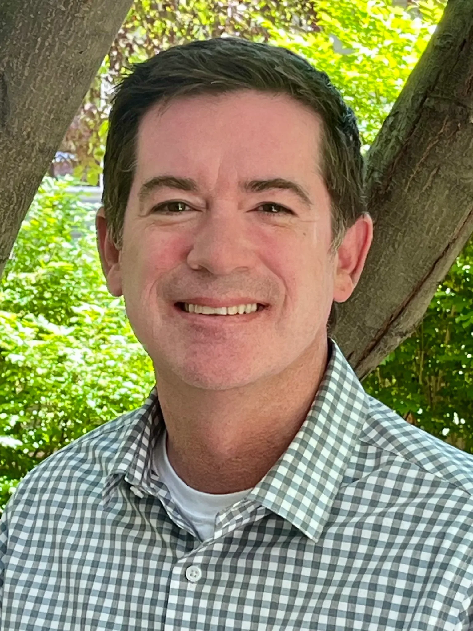 smiling man in a green checkered shirt