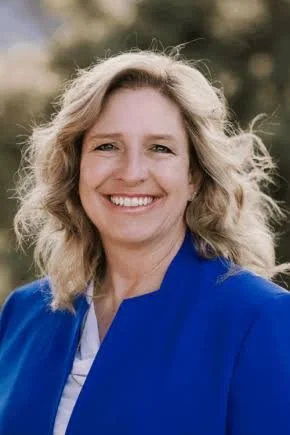 smiling woman with blonde hair and a blue suit
