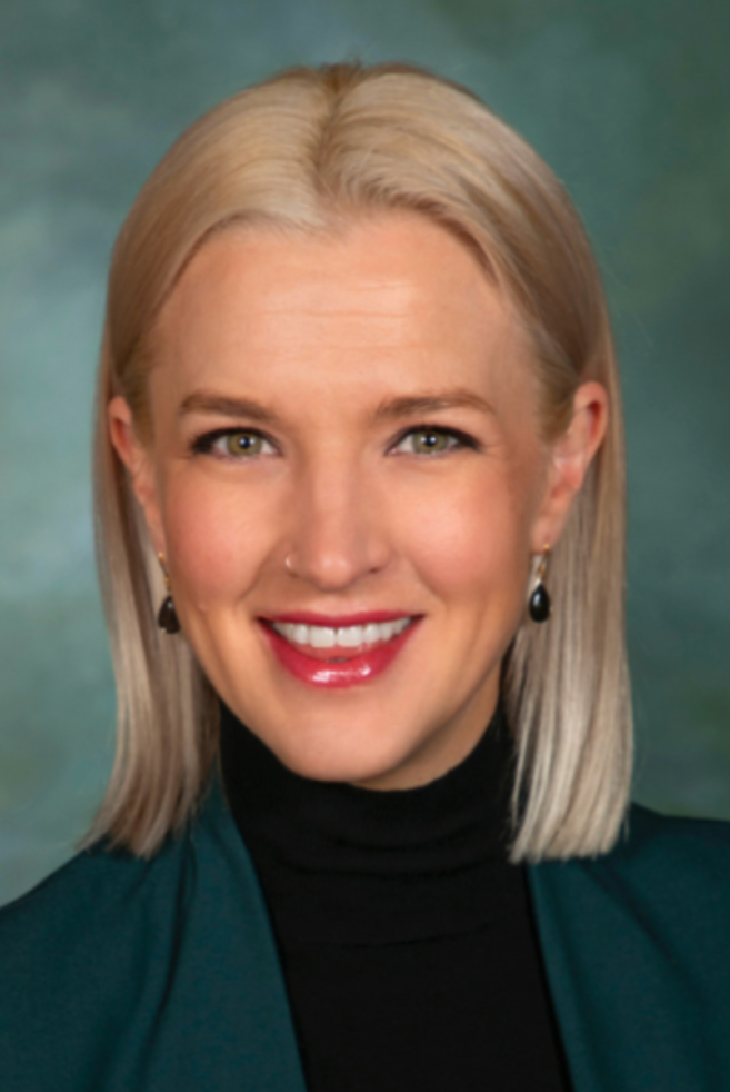 Smiling woman with blonde hair and green jacket