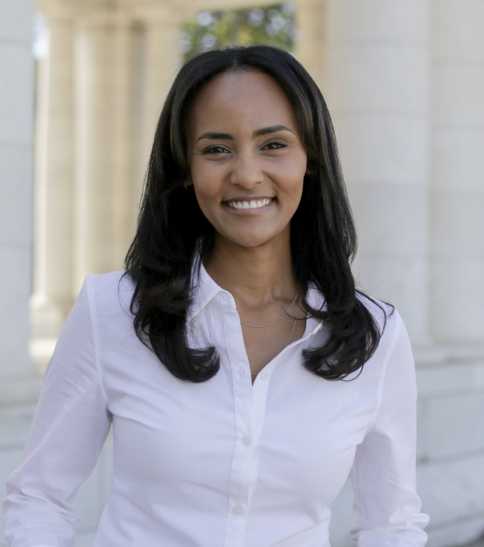 Smiling woman with dark brown hair and a white button down shirt