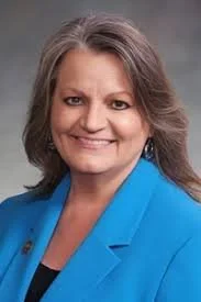 Smiling woman with brown hair and blue jacket