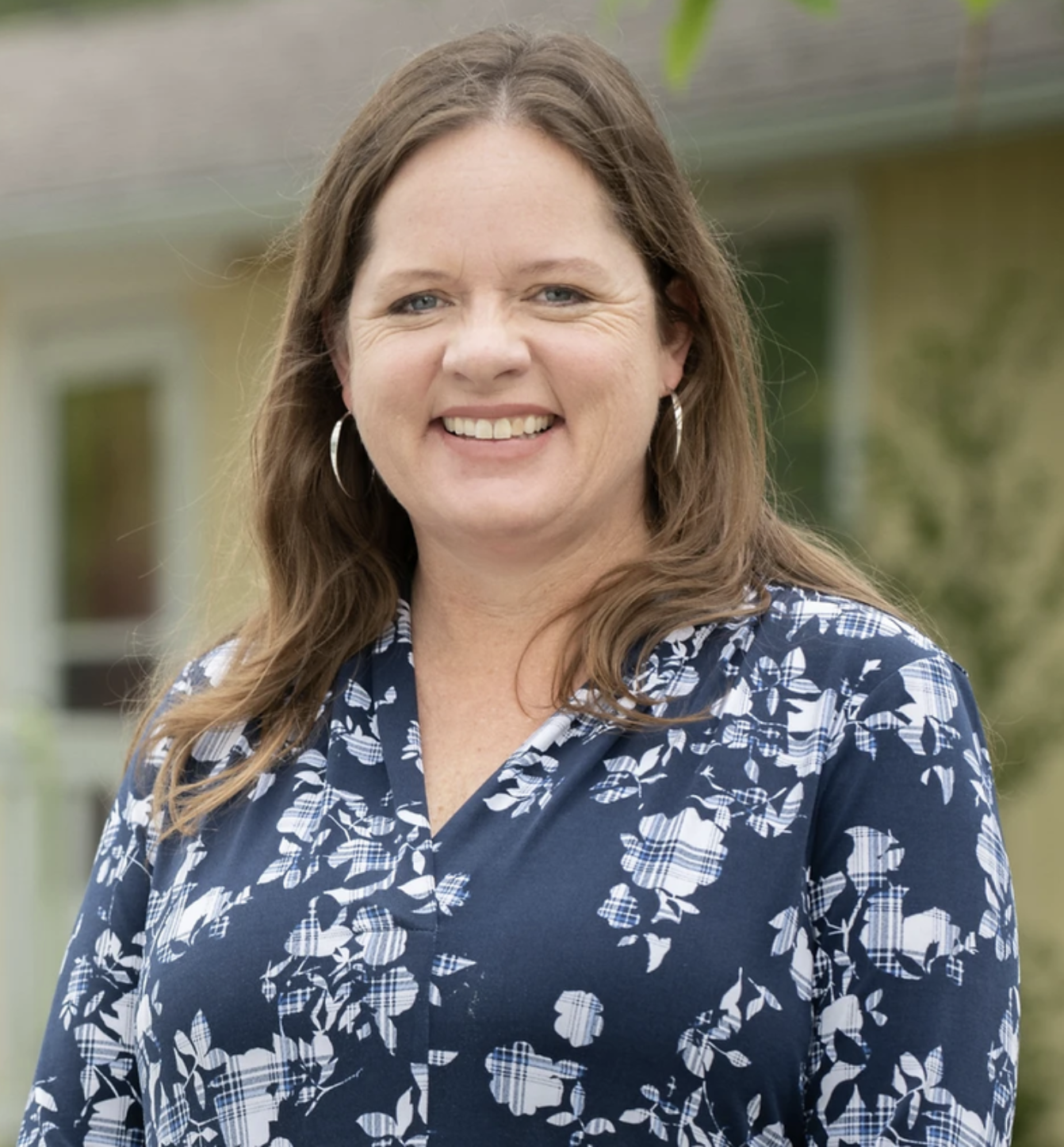 Smiling woman wearing a blue flowered shirt
