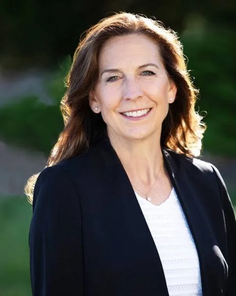 Smiling woman with brown hair and a dark blazer