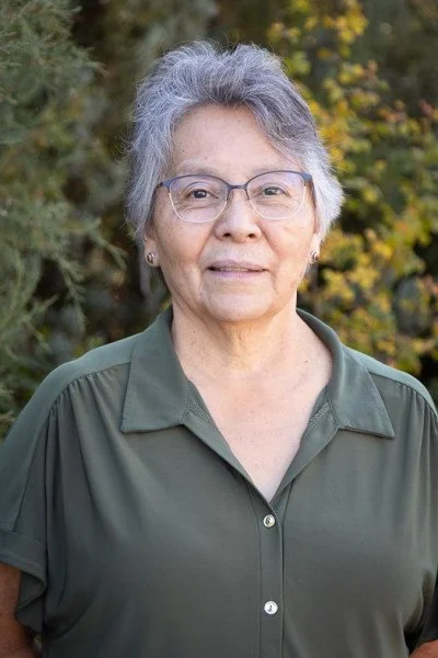 Smiling woman with silver hair and glasses