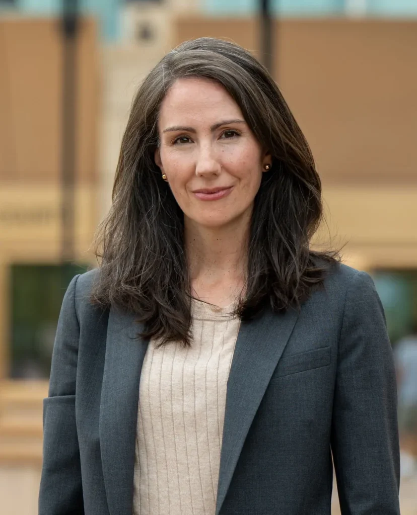 smiling woman with long brown hair and a suit jacket