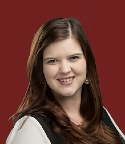 smiling woman with brown hair and a black vest
