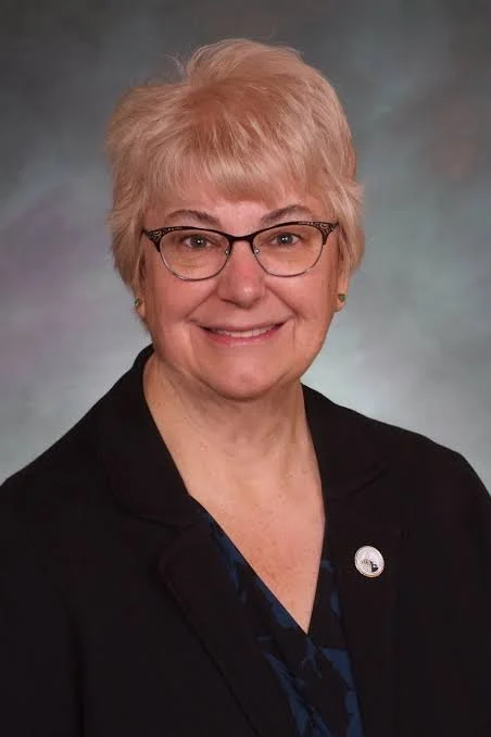 Smiling woman with glasses and a black shirt