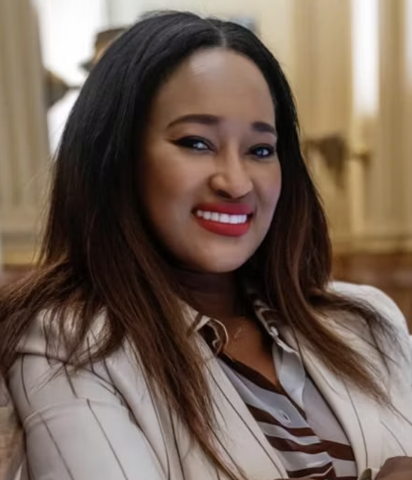 Smiling woman with long black hair and a white striped jacket
