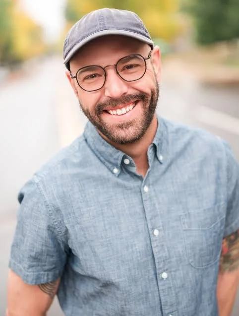 smiling man wearing a hat and glasses