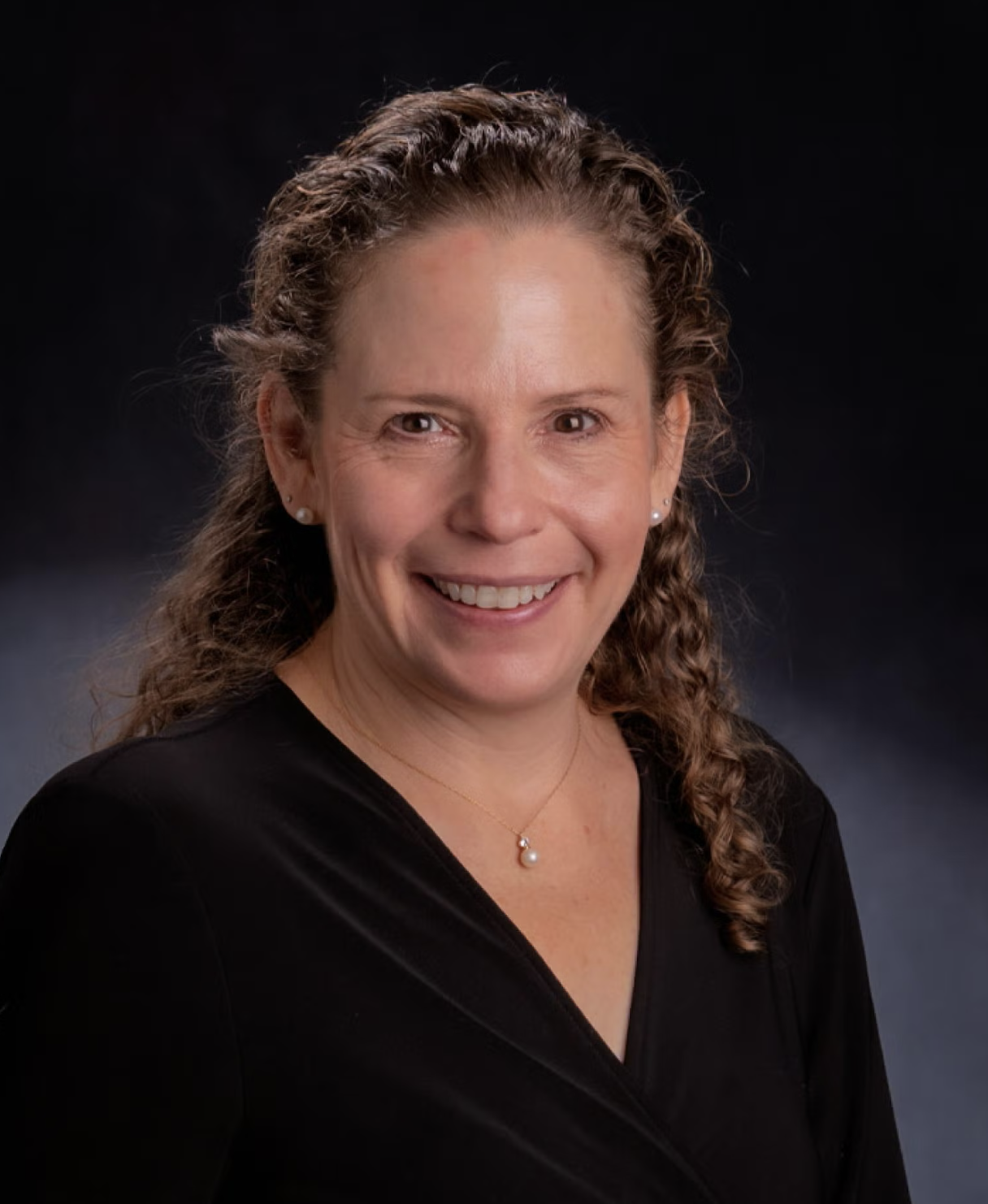 smiling woman with curly brown hair