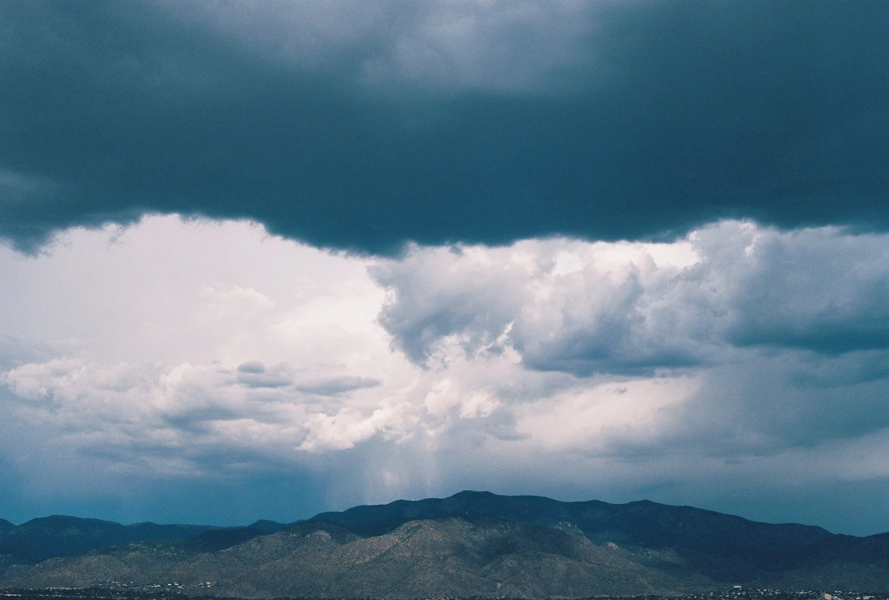 Mountain range beneath dramatic dark storm clouds