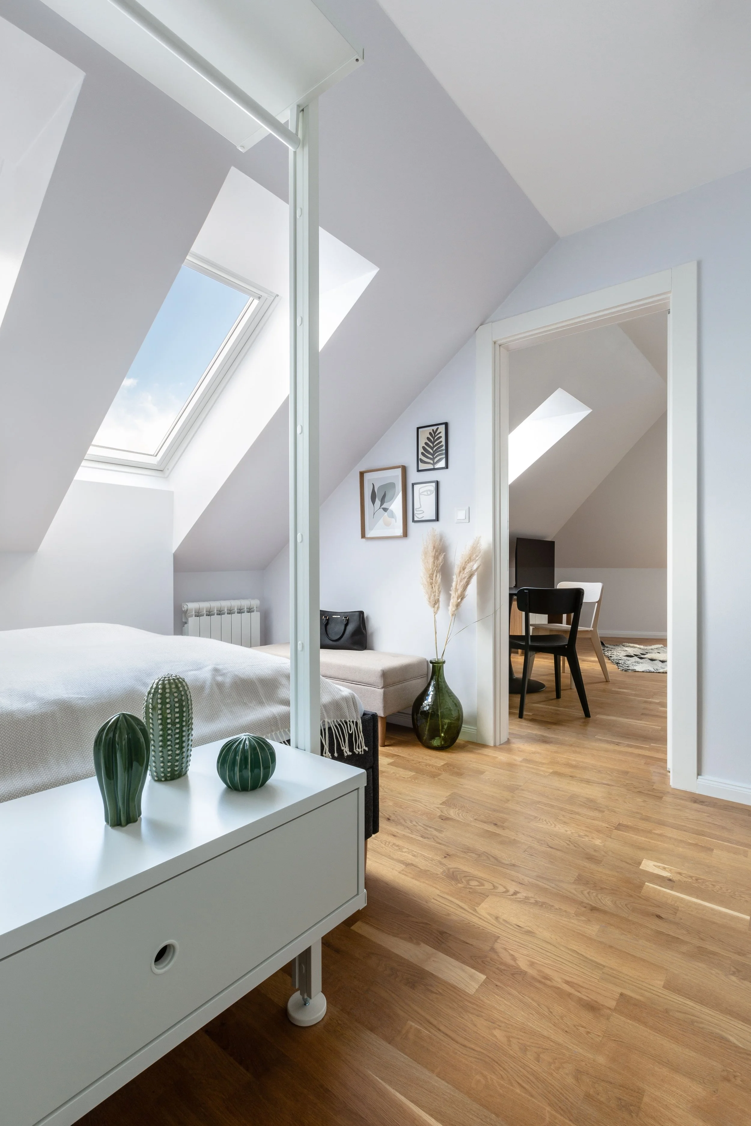 Loft bedroom with sloped ceiling, Velux skylight, and adjoining home office