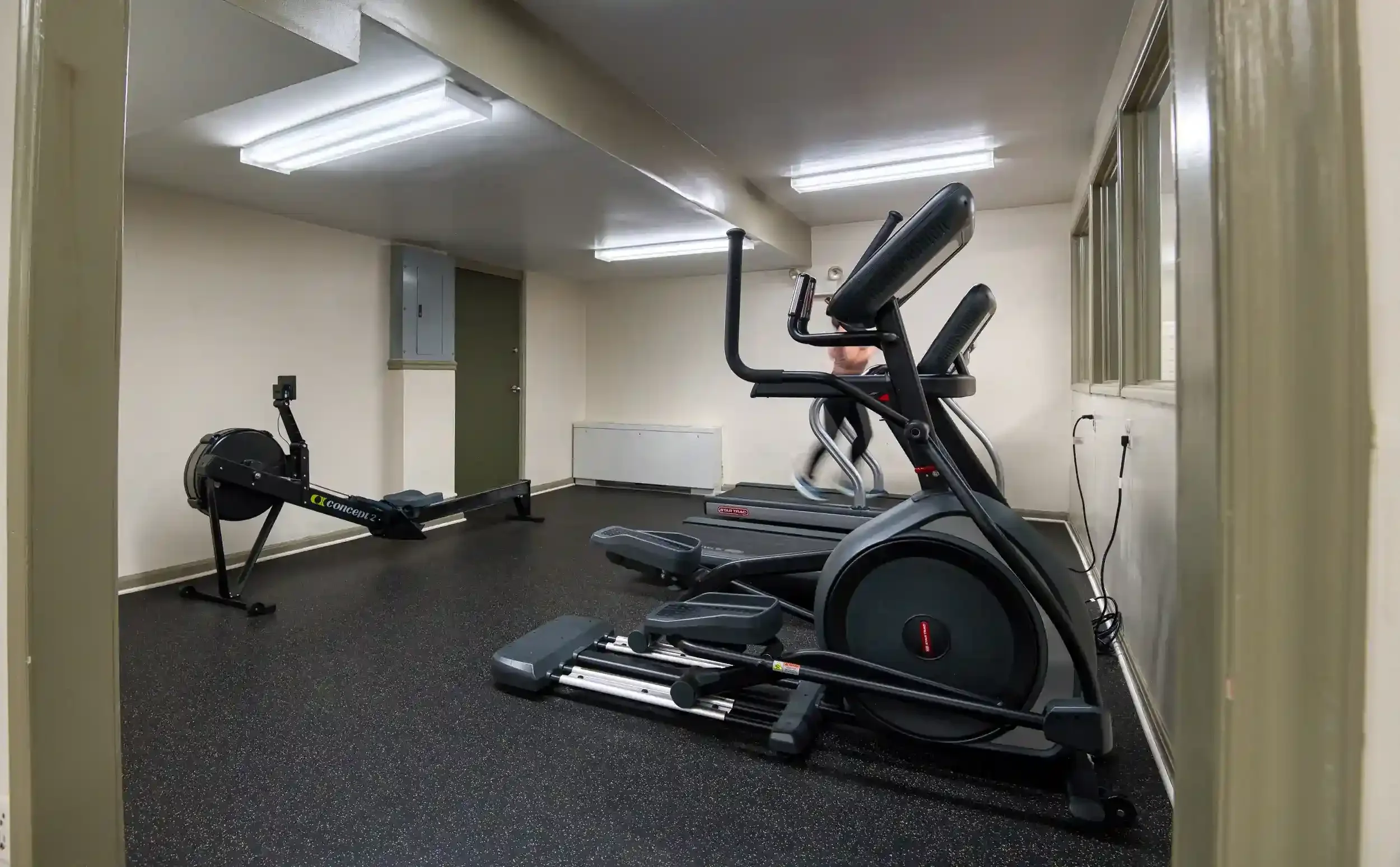 Fitness Room (View 2) – The Cardio Corner features a rowing machine and elliptical for varied cardio workouts.