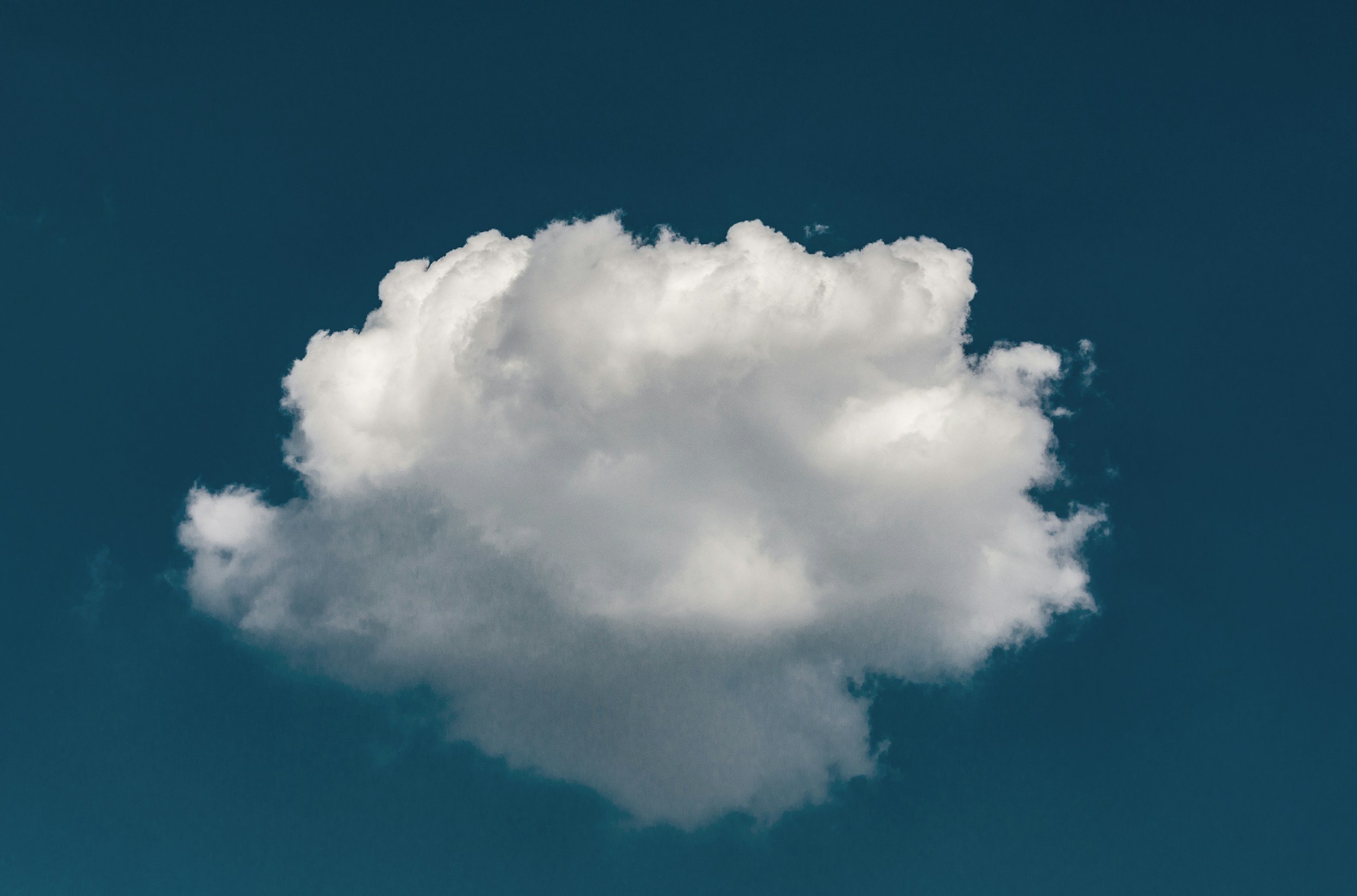 A white cloud against a deep blue sky.