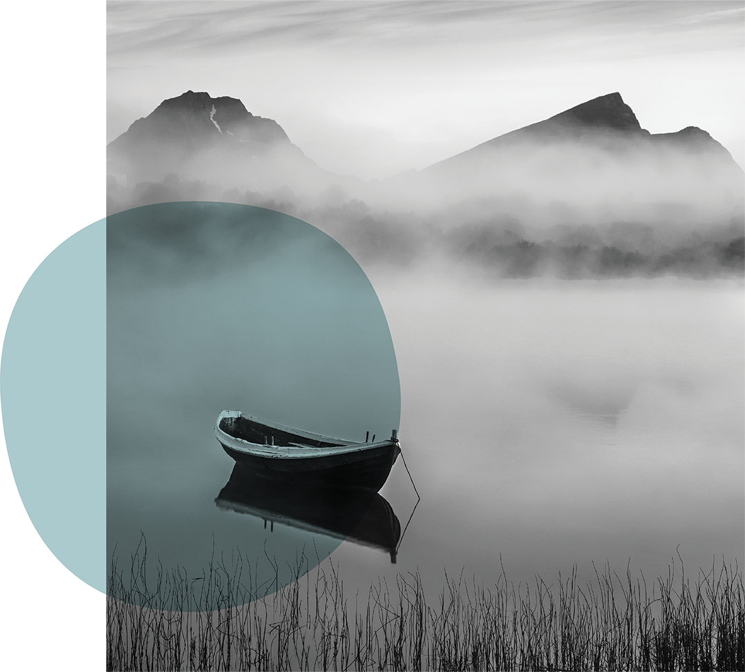 A black and white photo of a boat floating on a calm lake, with misty mountains in the background and tall grass in the foreground. There is a teal circle and shape overlay on the left side of the image.