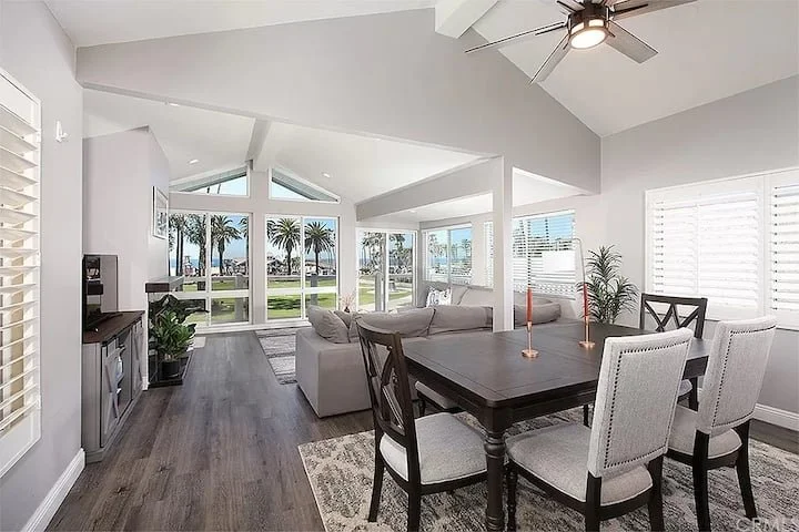 Living room with fireplace and large windows overlooking the palm-lined waterfront