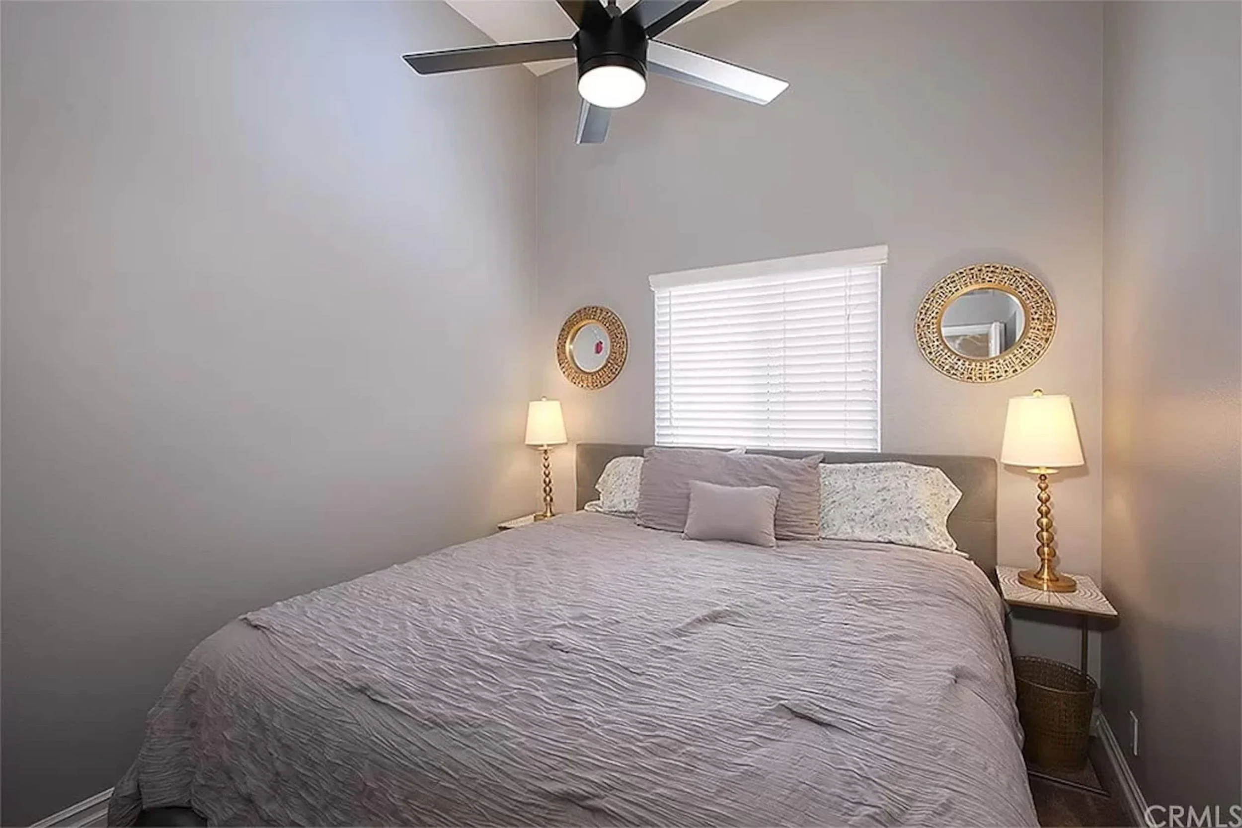 Bedroom with a plush bed, round mirrors, and warm lighting