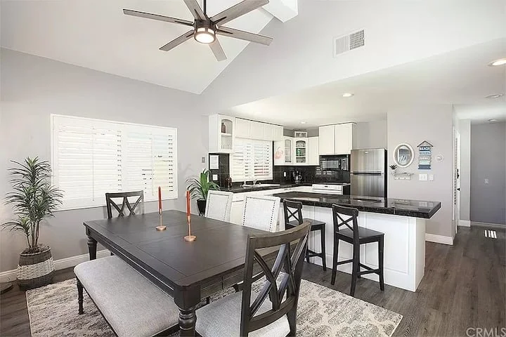 Dining table with seating beside the open kitchen and breakfast bar